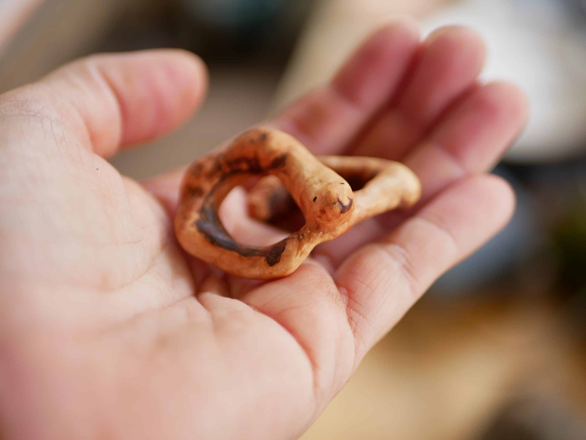 Handschmeichler in Schlangenform aus einer Baumperle
