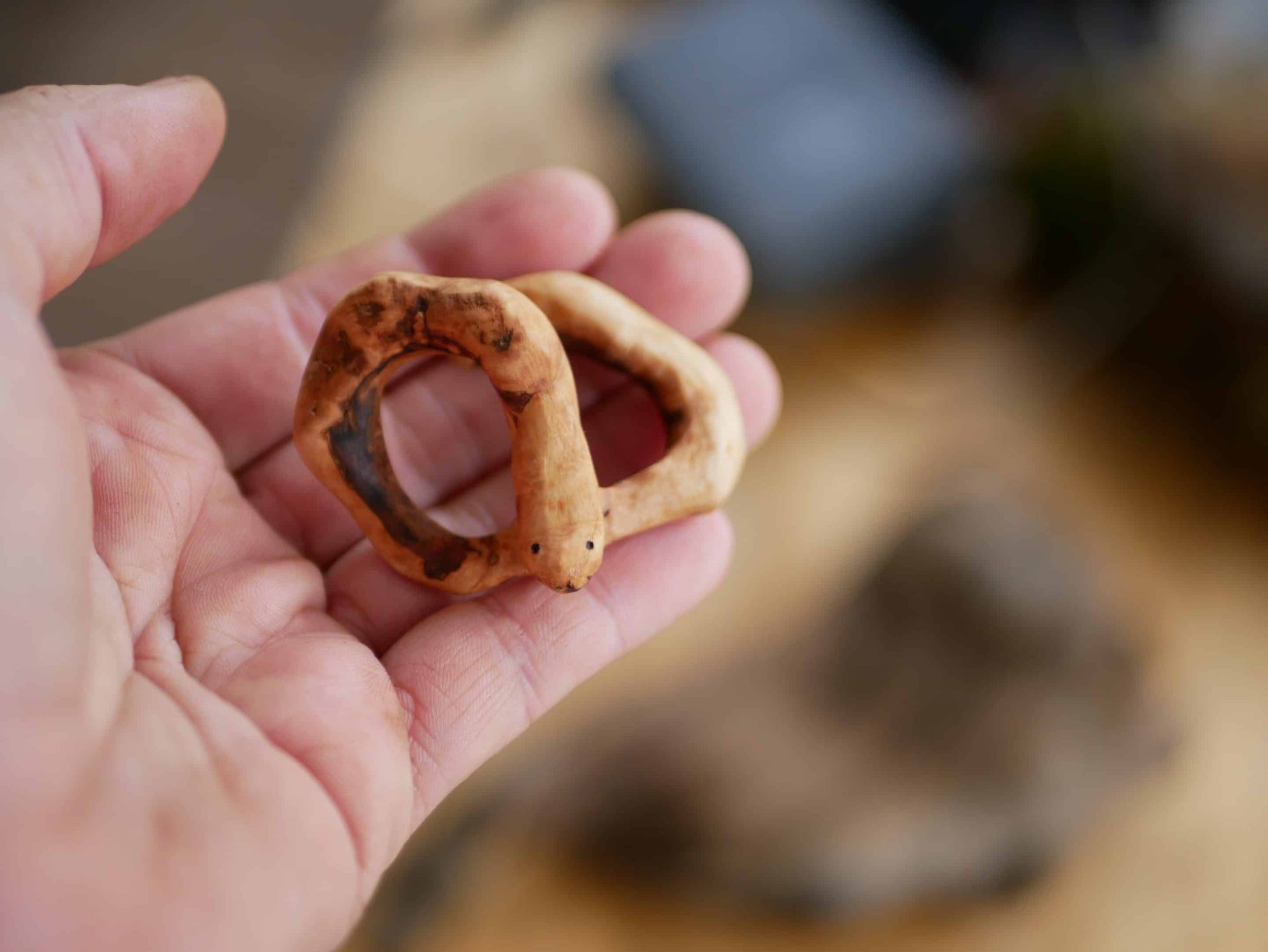 Handschmeichler in Schlangenform aus einer Baumperle