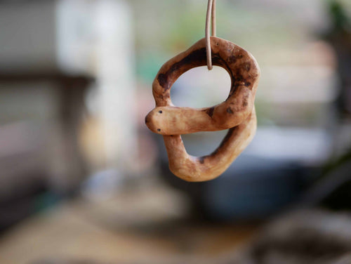 Handschmeichler in Schlangenform aus einer Baumperle