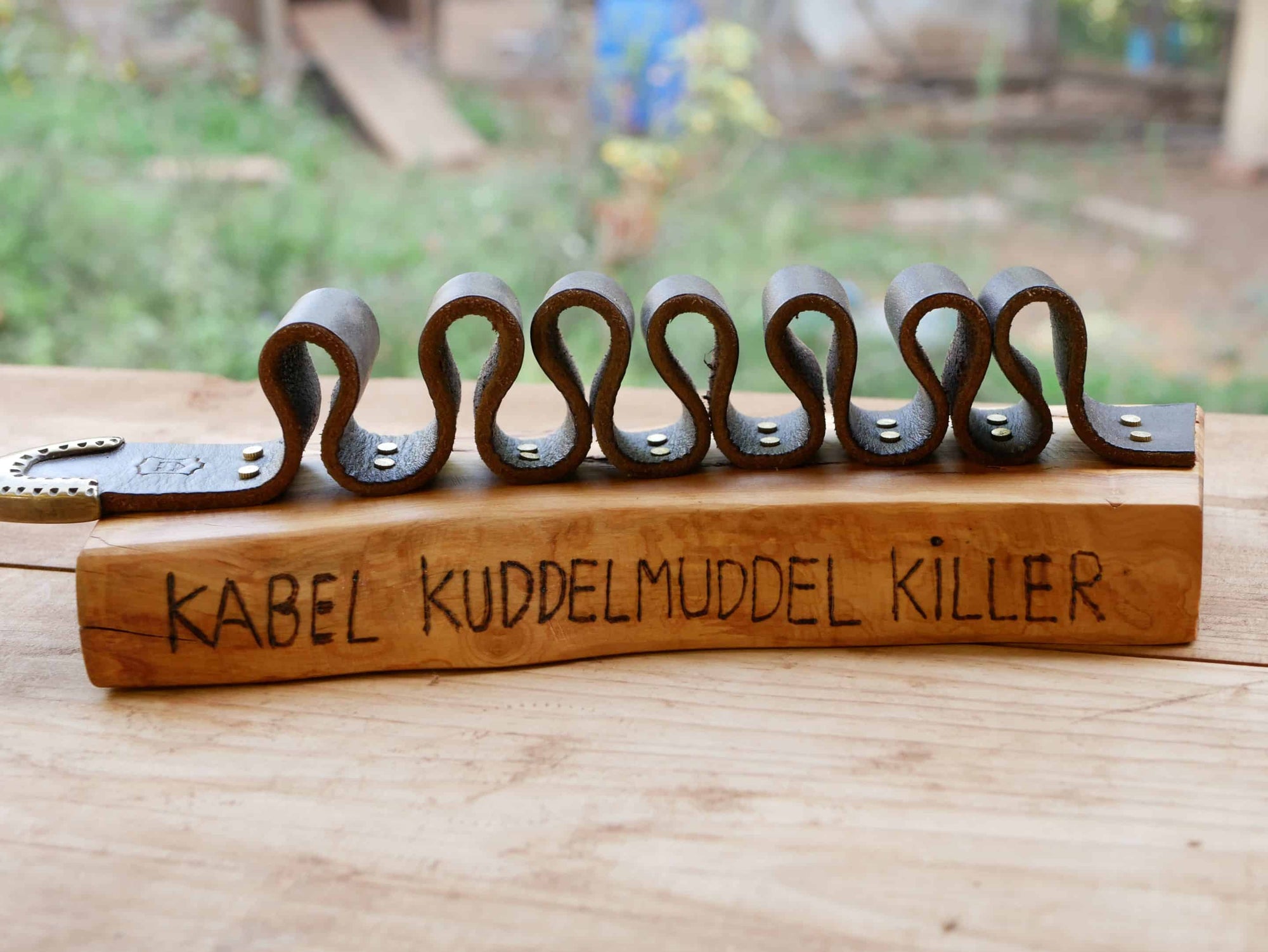 Rustikaler Kabelhalter aus Olivenholz und einem alten Gürtel