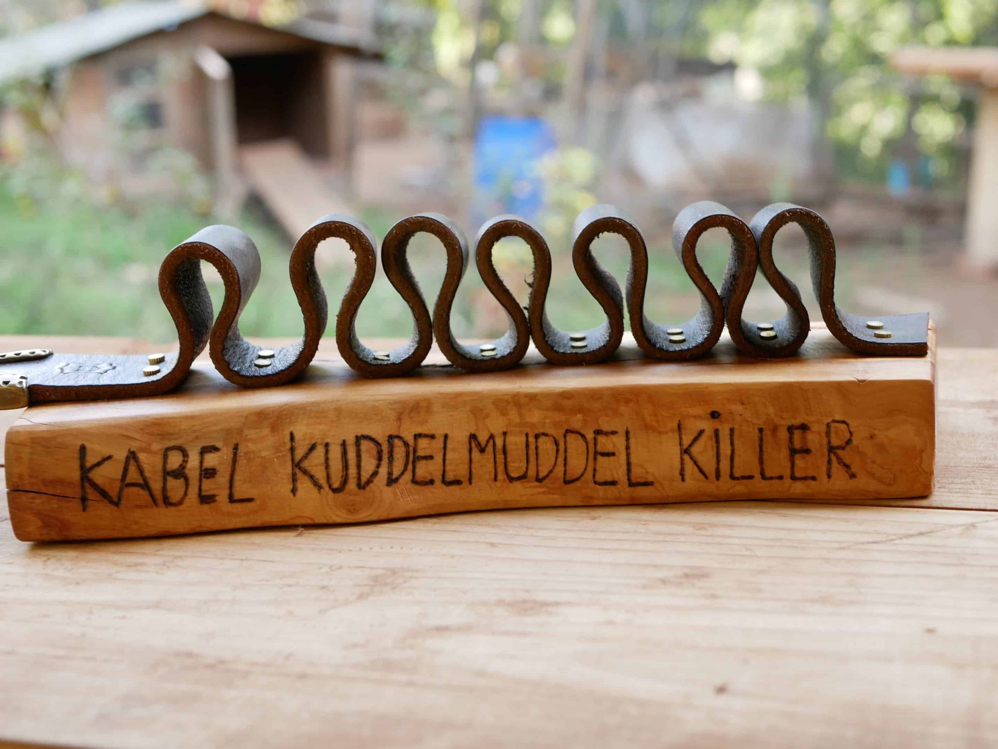 Rustikaler Kabelhalter aus Olivenholz und einem alten Gürtel