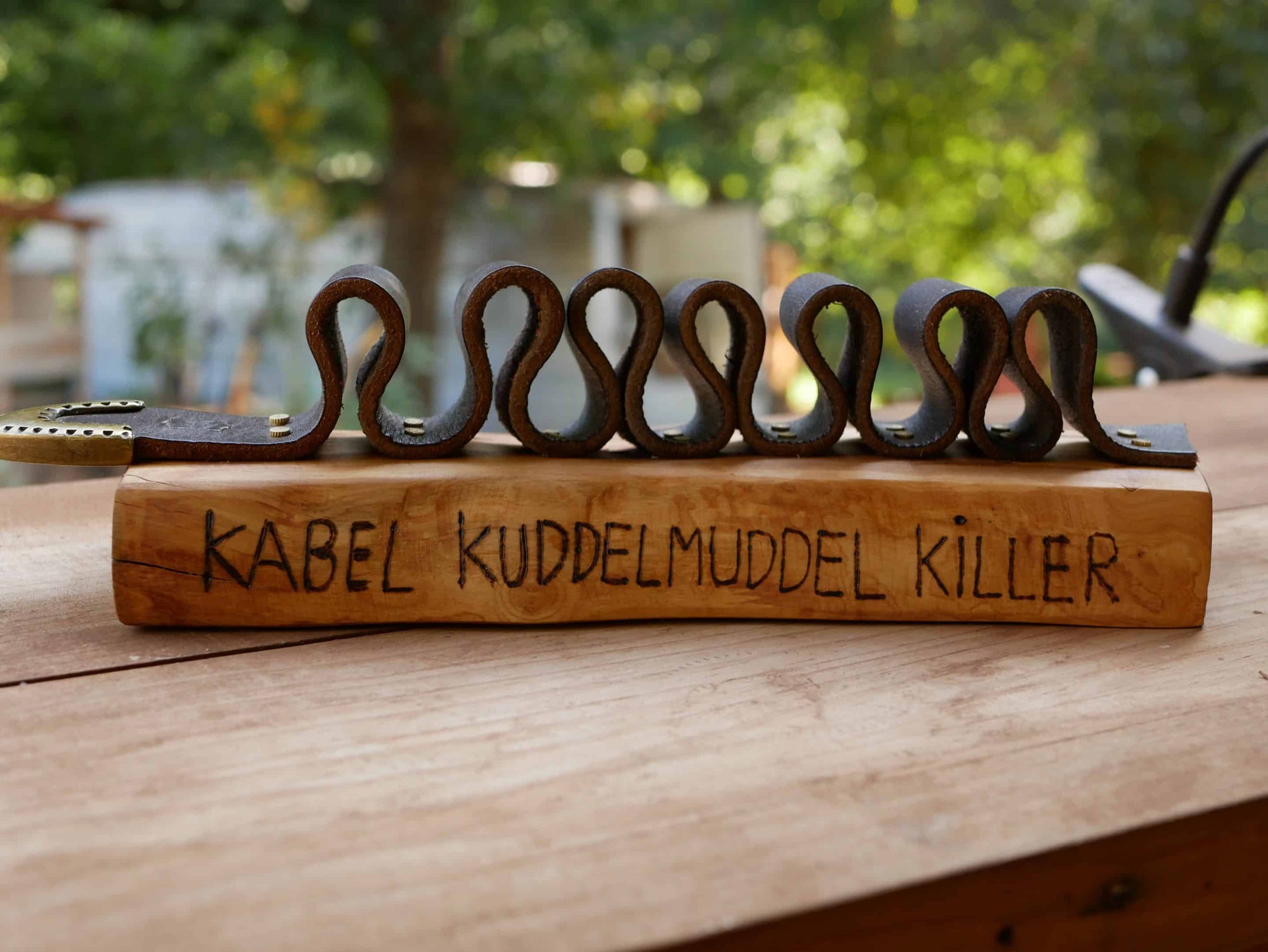 Rustikaler Kabelhalter aus Olivenholz und einem alten Gürtel
