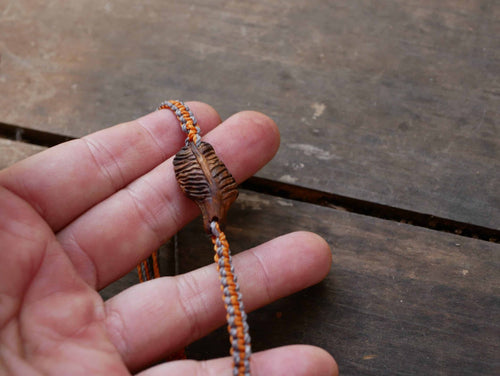Makramee Armband mit einer Baumperle als Feder geschnitzt
