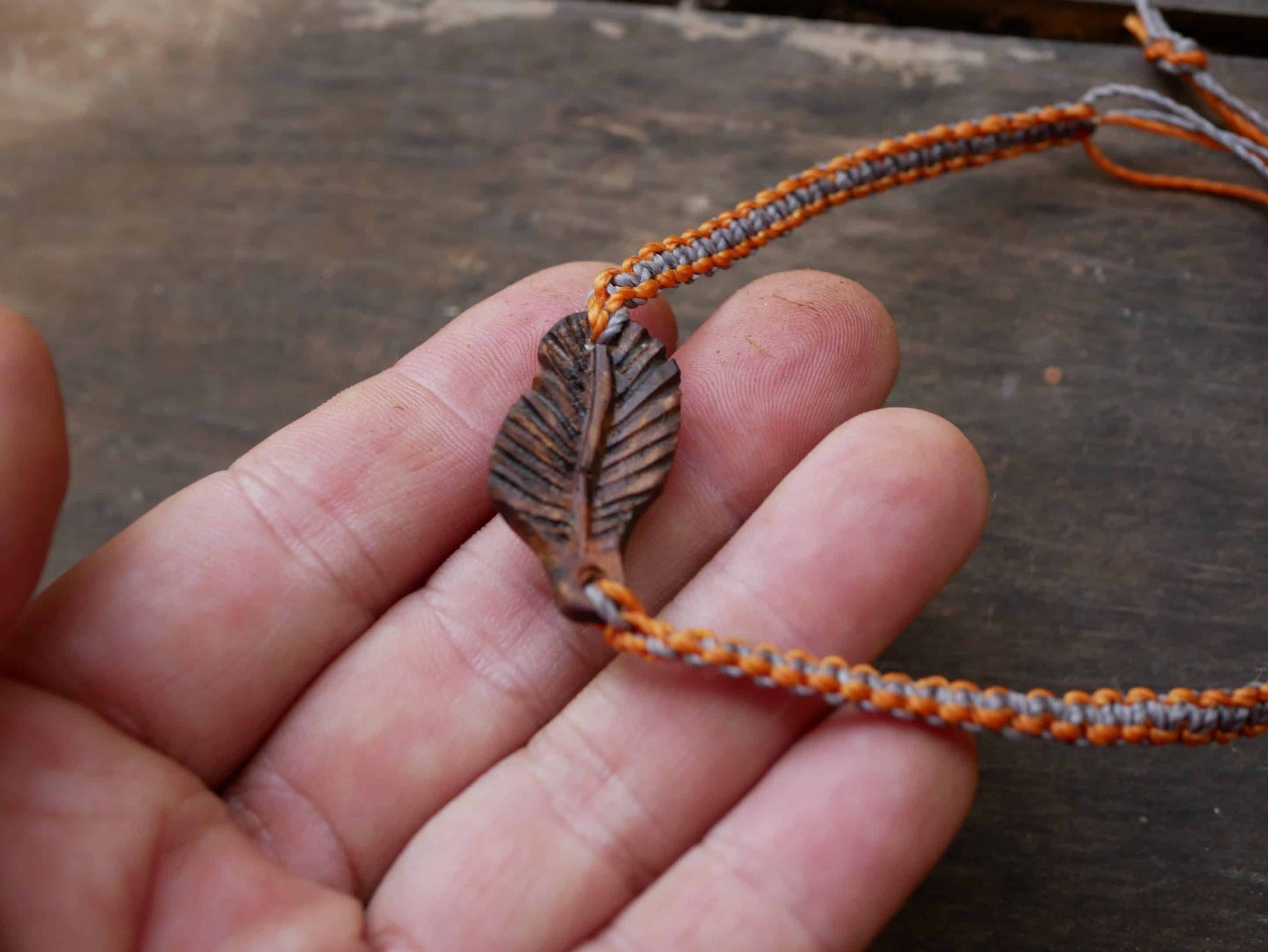 Makramee Armband mit einer Baumperle als Feder geschnitzt
