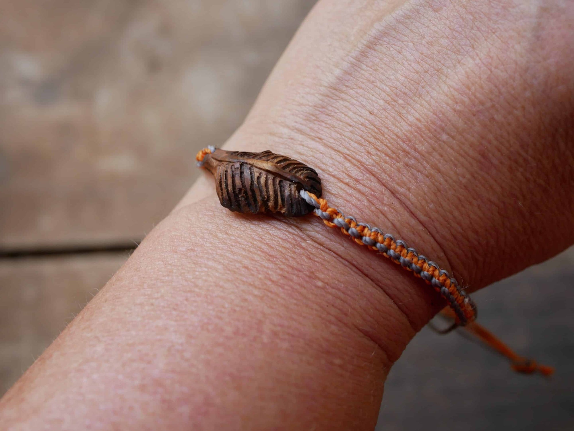 Makramee Armband mit einer Baumperle als Feder geschnitzt