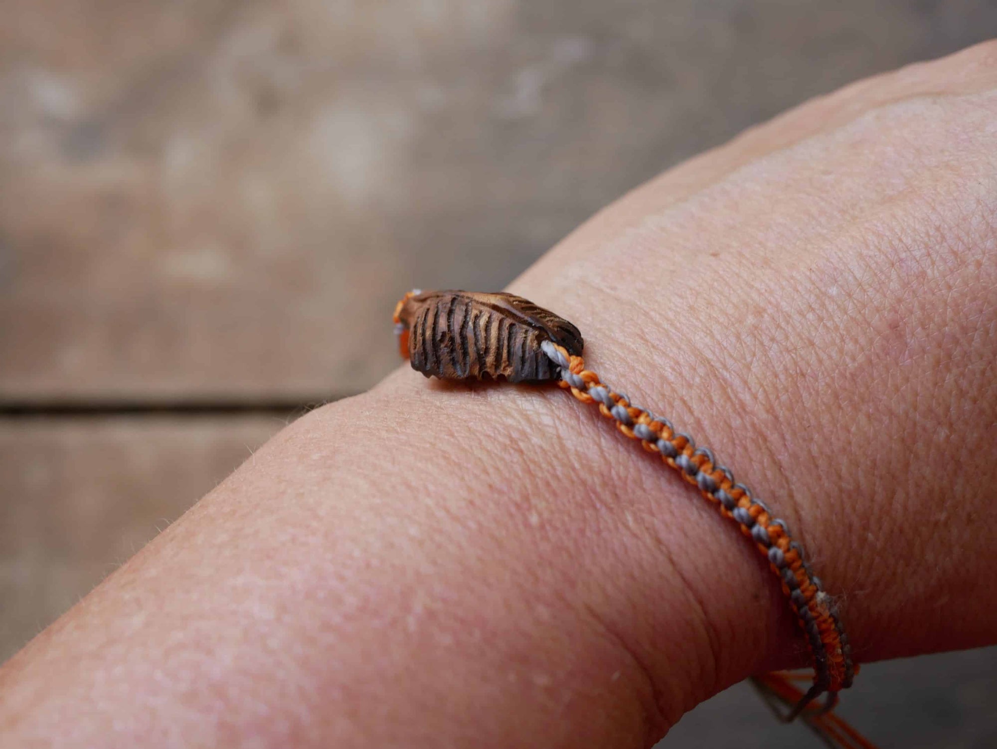 Makramee Armband mit einer Baumperle als Feder geschnitzt