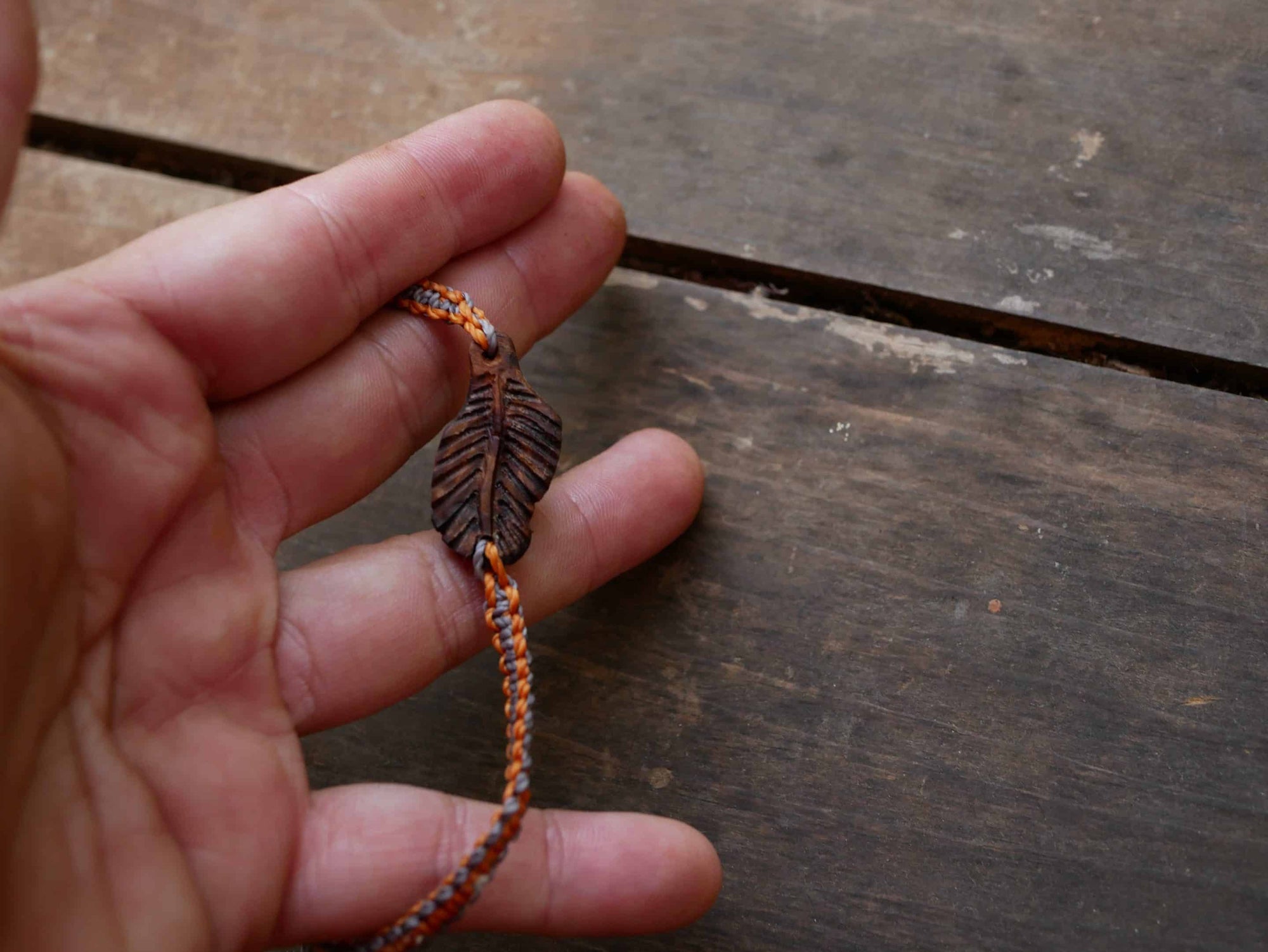 Makramee Armband mit einer Baumperle als Feder geschnitzt