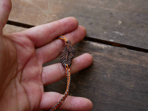 Makramee Armband mit einer Baumperle als Feder geschnitzt