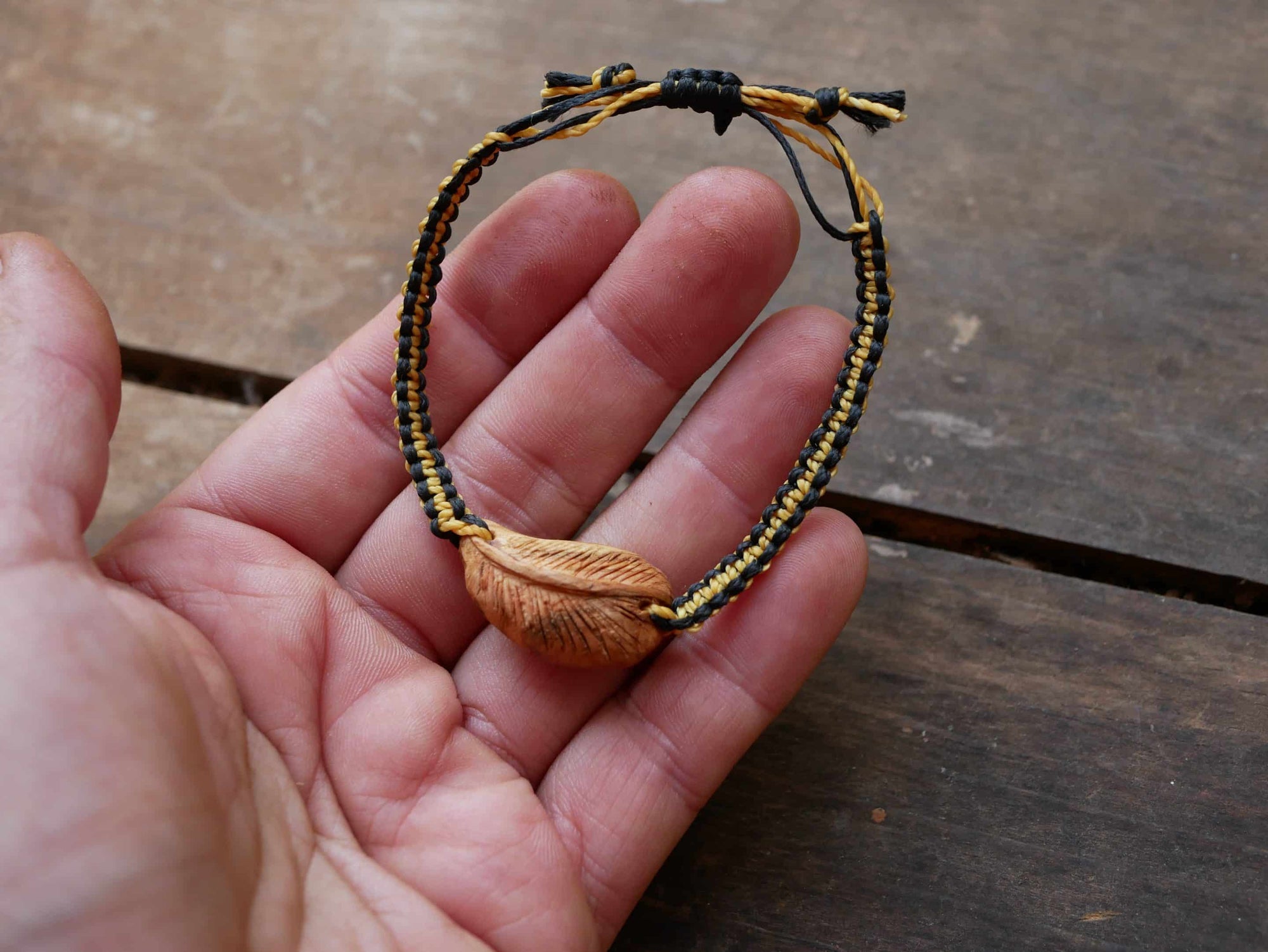 Makramee Armband mit einer Baumperle als Feder geschnitzt