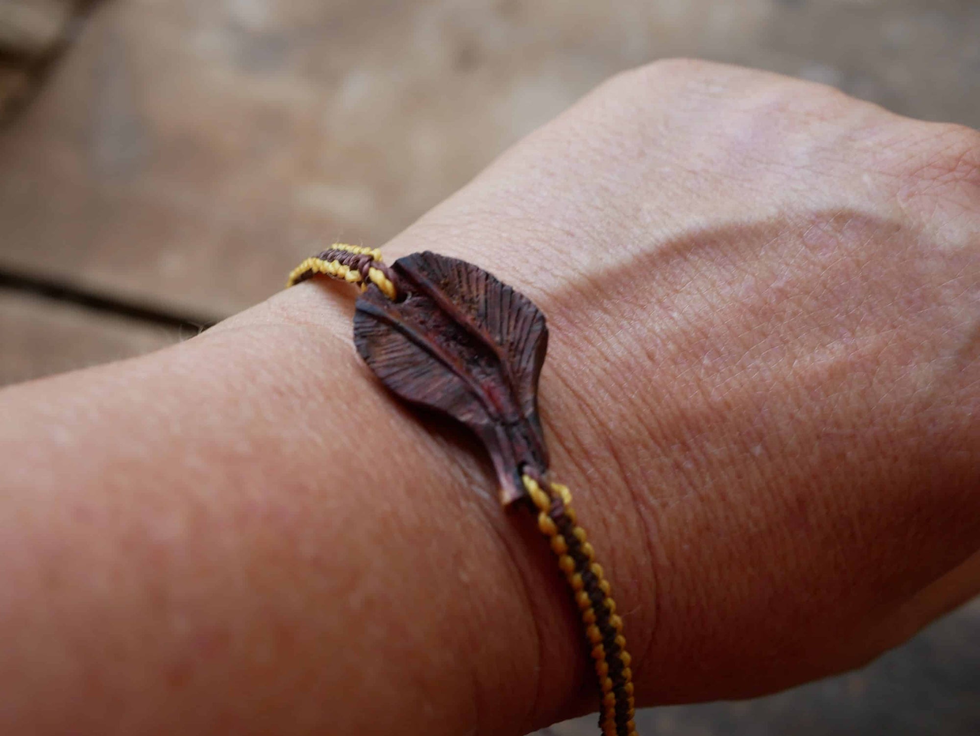 Makramee Armband mit einer Baumperle als Feder geschnitzt