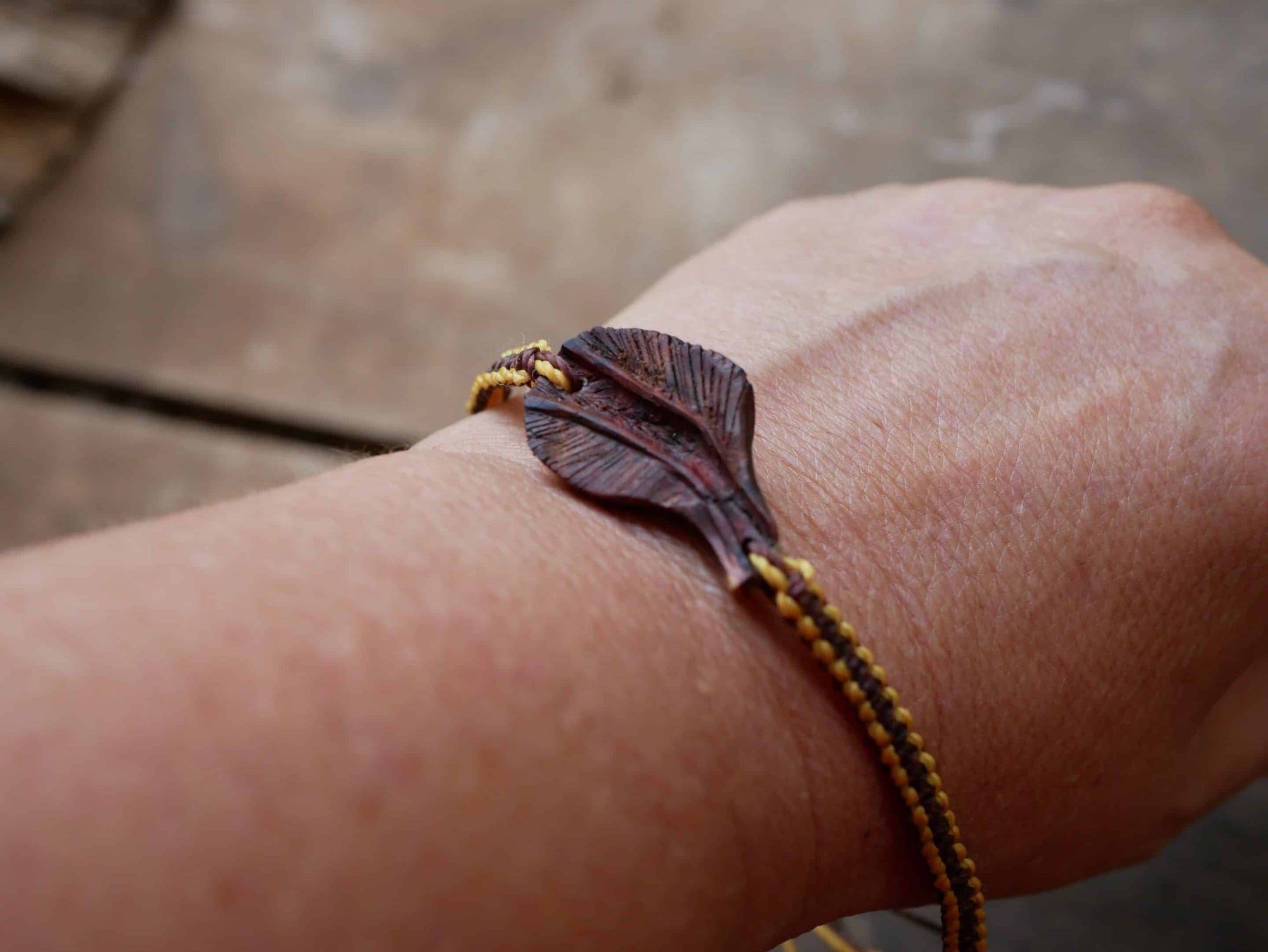 Makramee Armband mit einer Baumperle als Feder geschnitzt