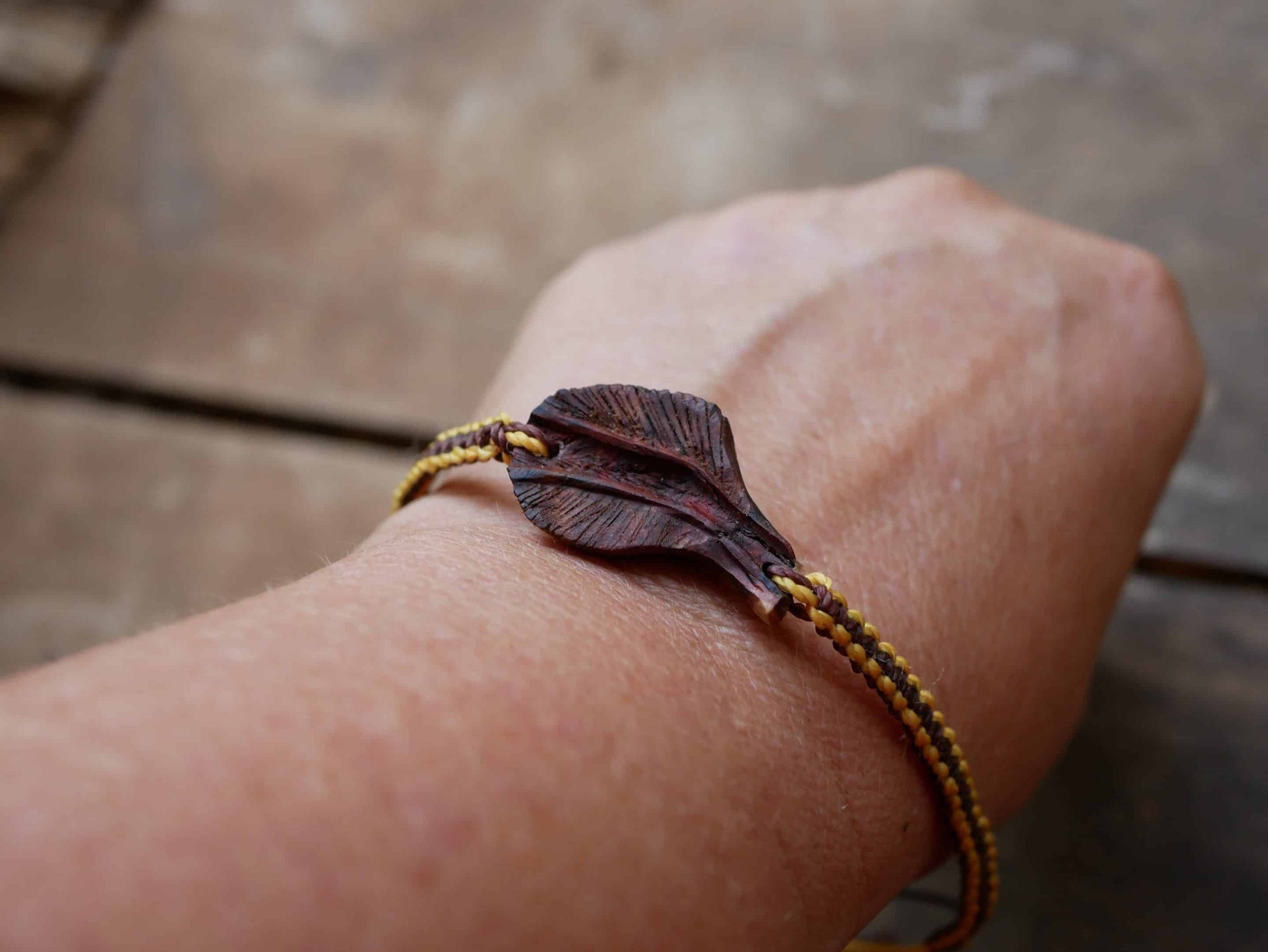 Makramee Armband mit einer Baumperle als Feder geschnitzt