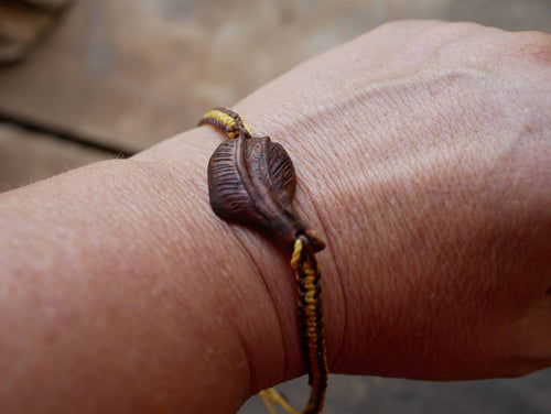 Makramee Armband mit einer Baumperle als Feder geschnitzt