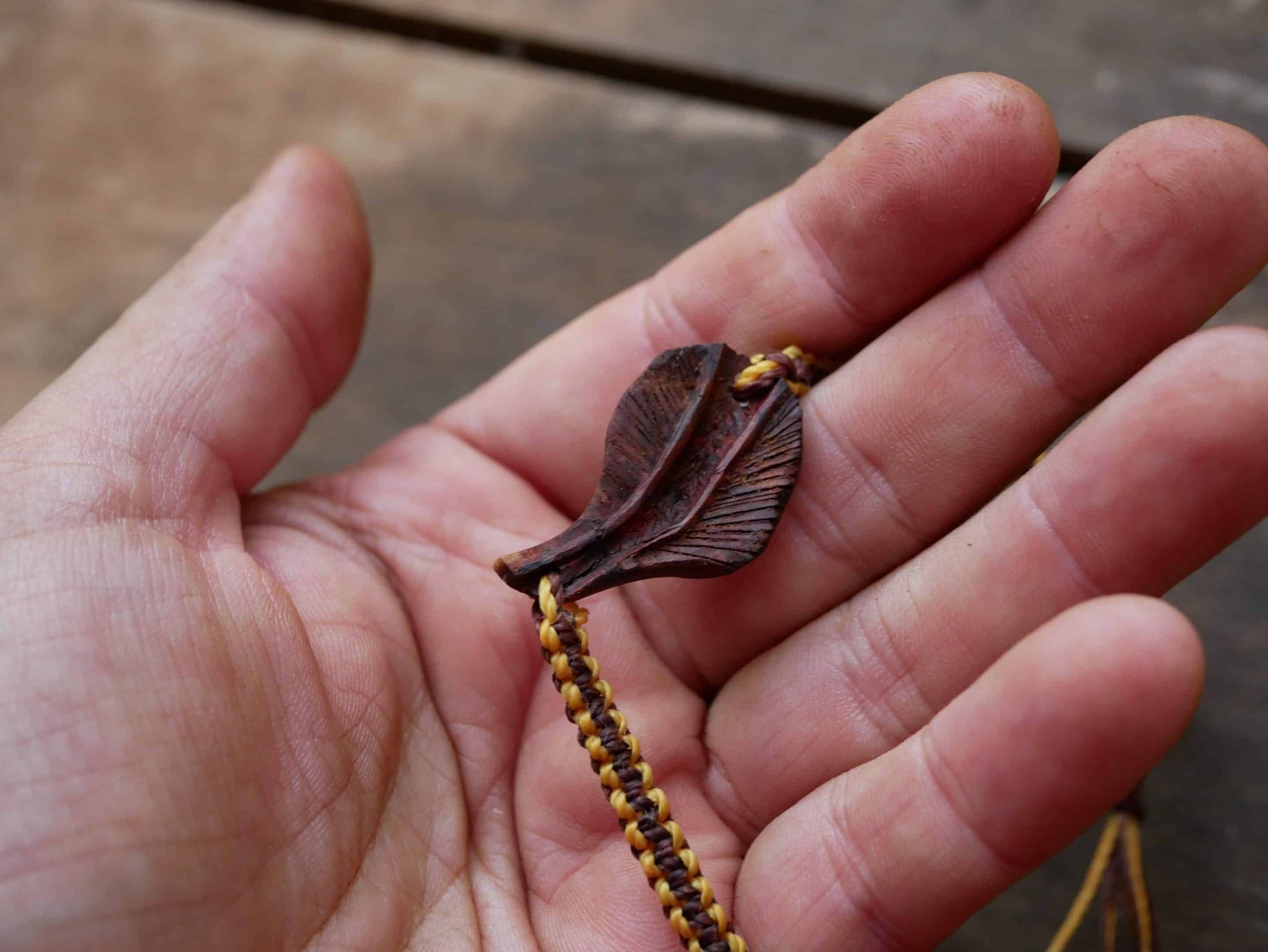 Makramee Armband mit einer Baumperle als Feder geschnitzt