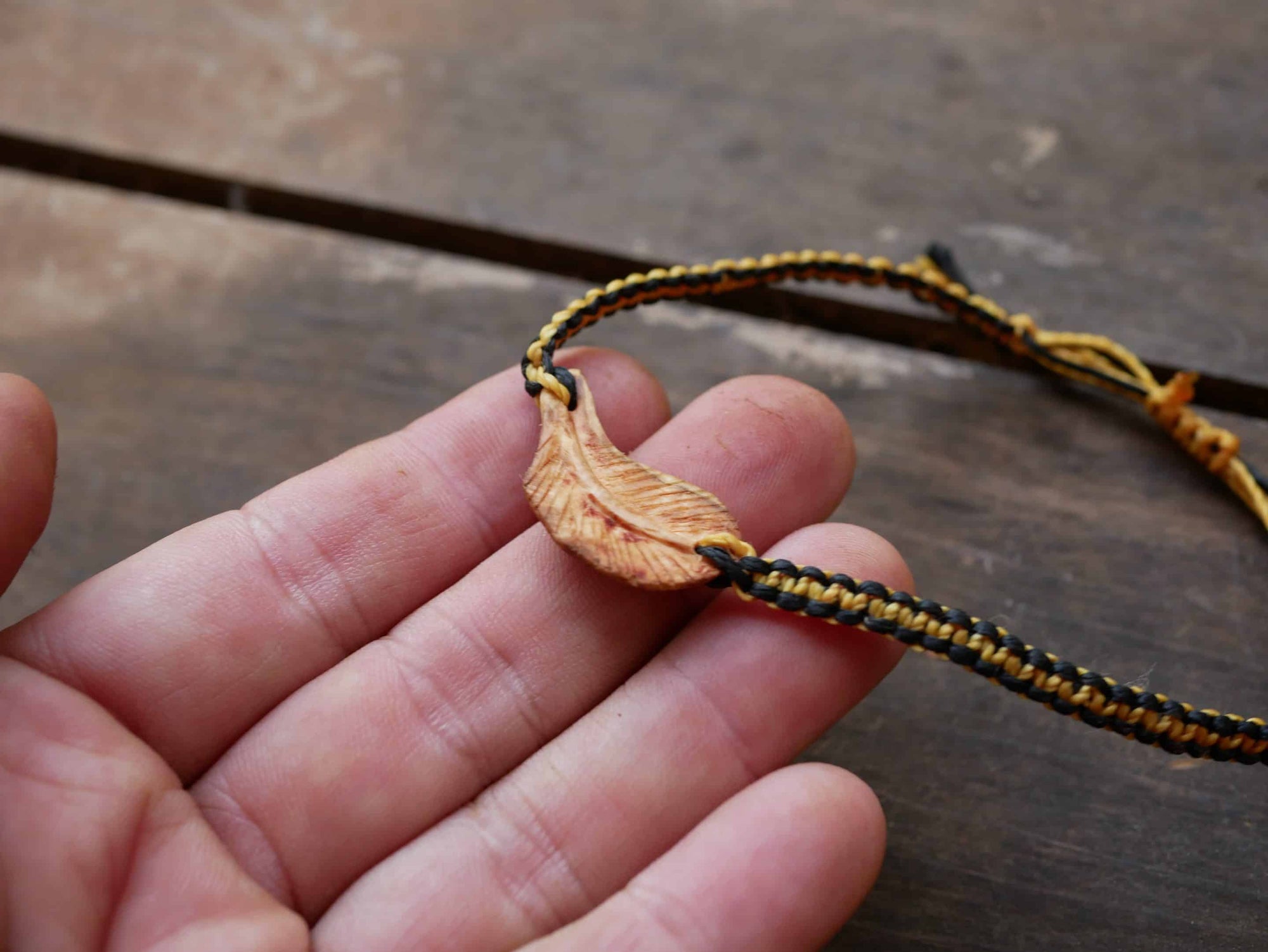 Makramee Armband mit einer Baumperle als Feder geschnitzt