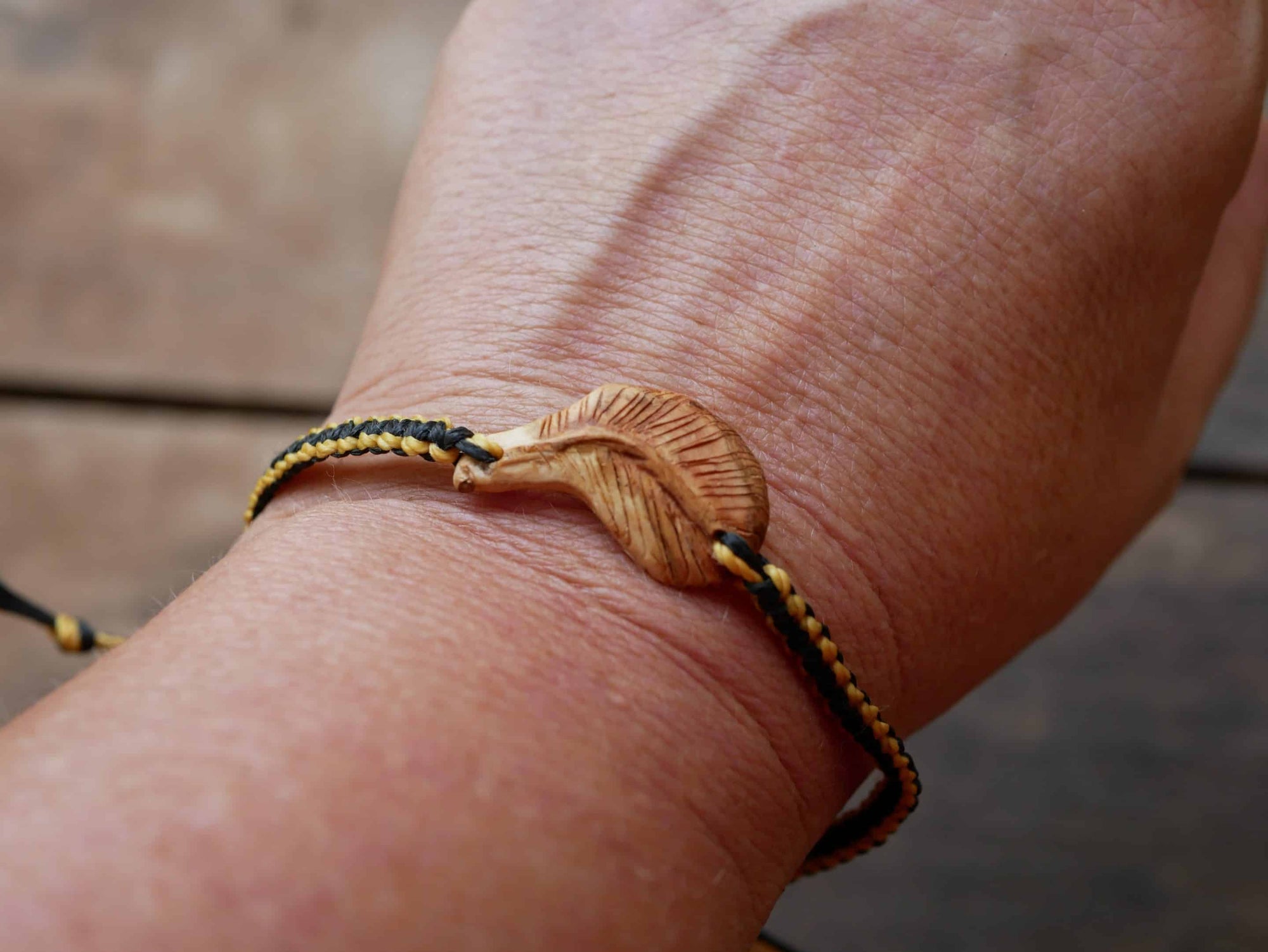 Makramee Armband mit einer Baumperle als Feder geschnitzt
