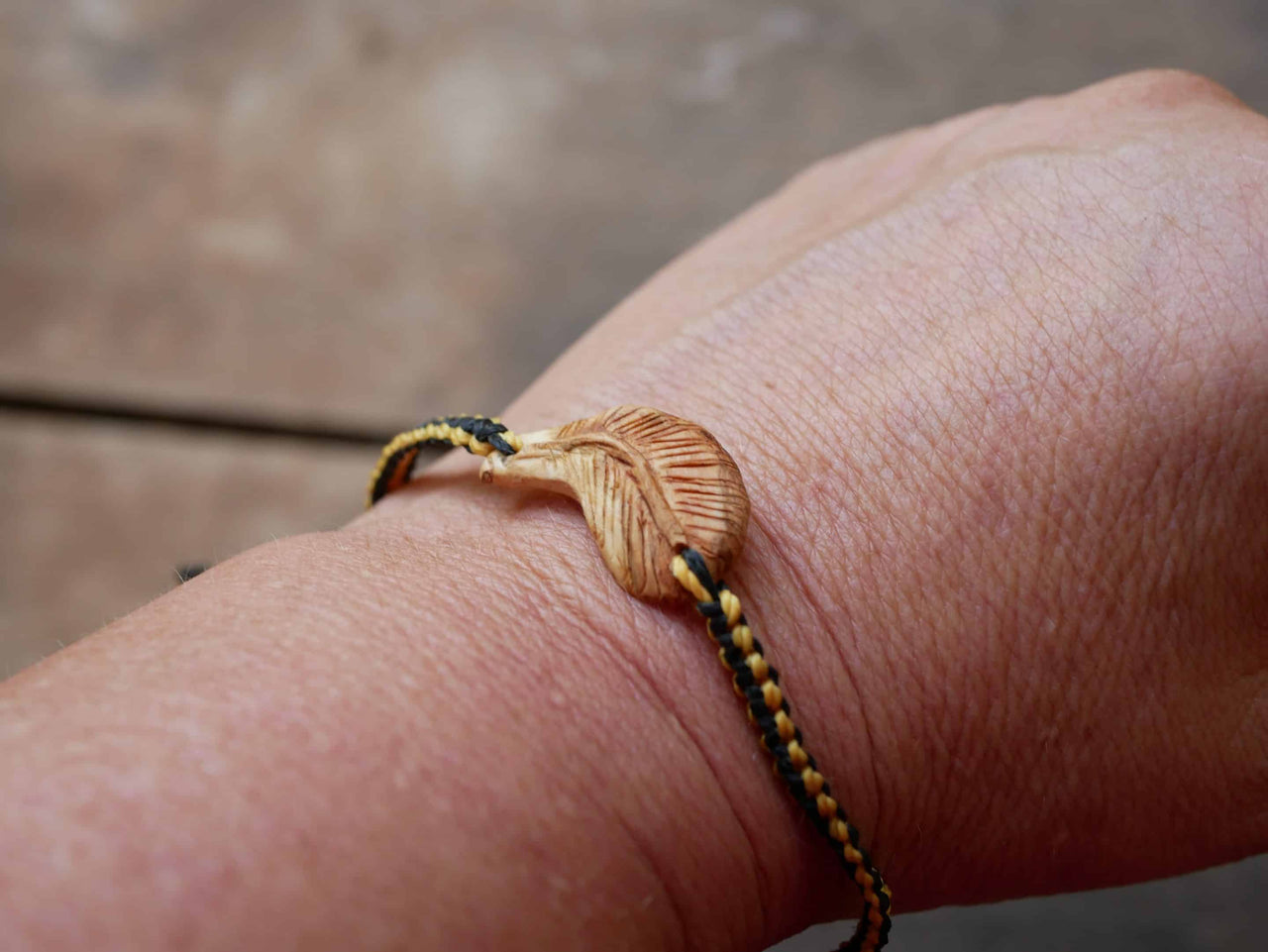 Makramee Armband mit einer Baumperle als Feder geschnitzt