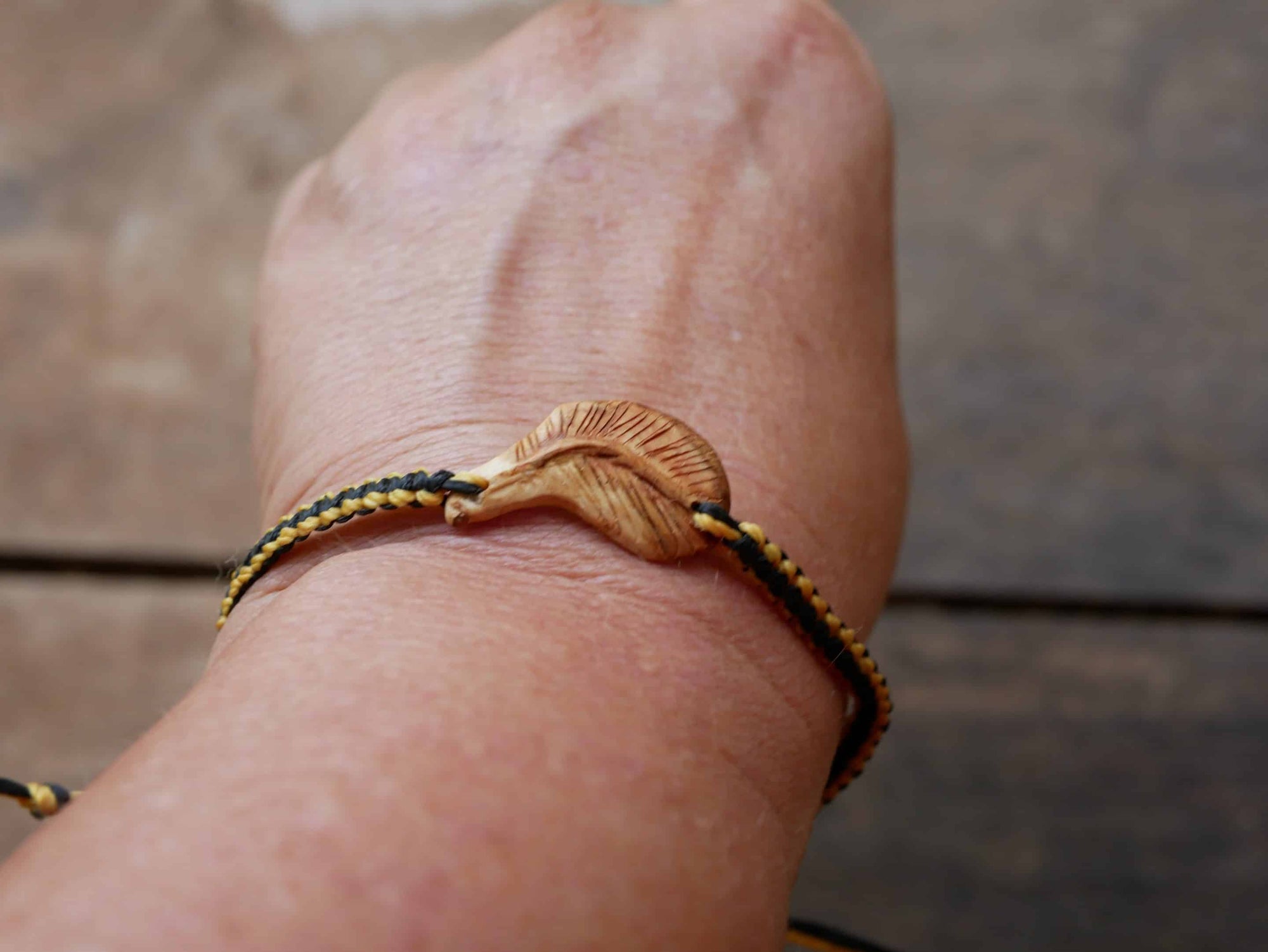 Makramee Armband mit einer Baumperle als Feder geschnitzt
