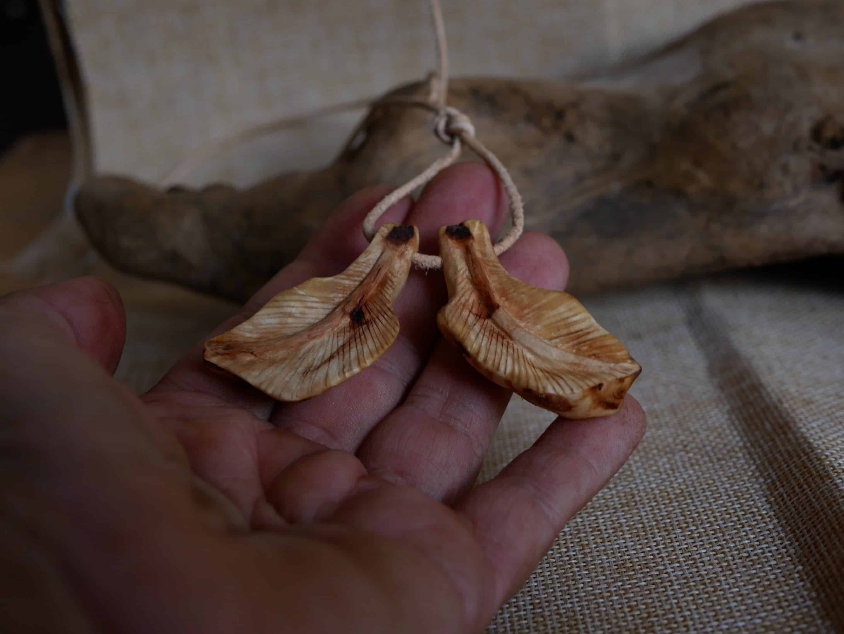 Federanhänger aus Baumperlen geschnitzt