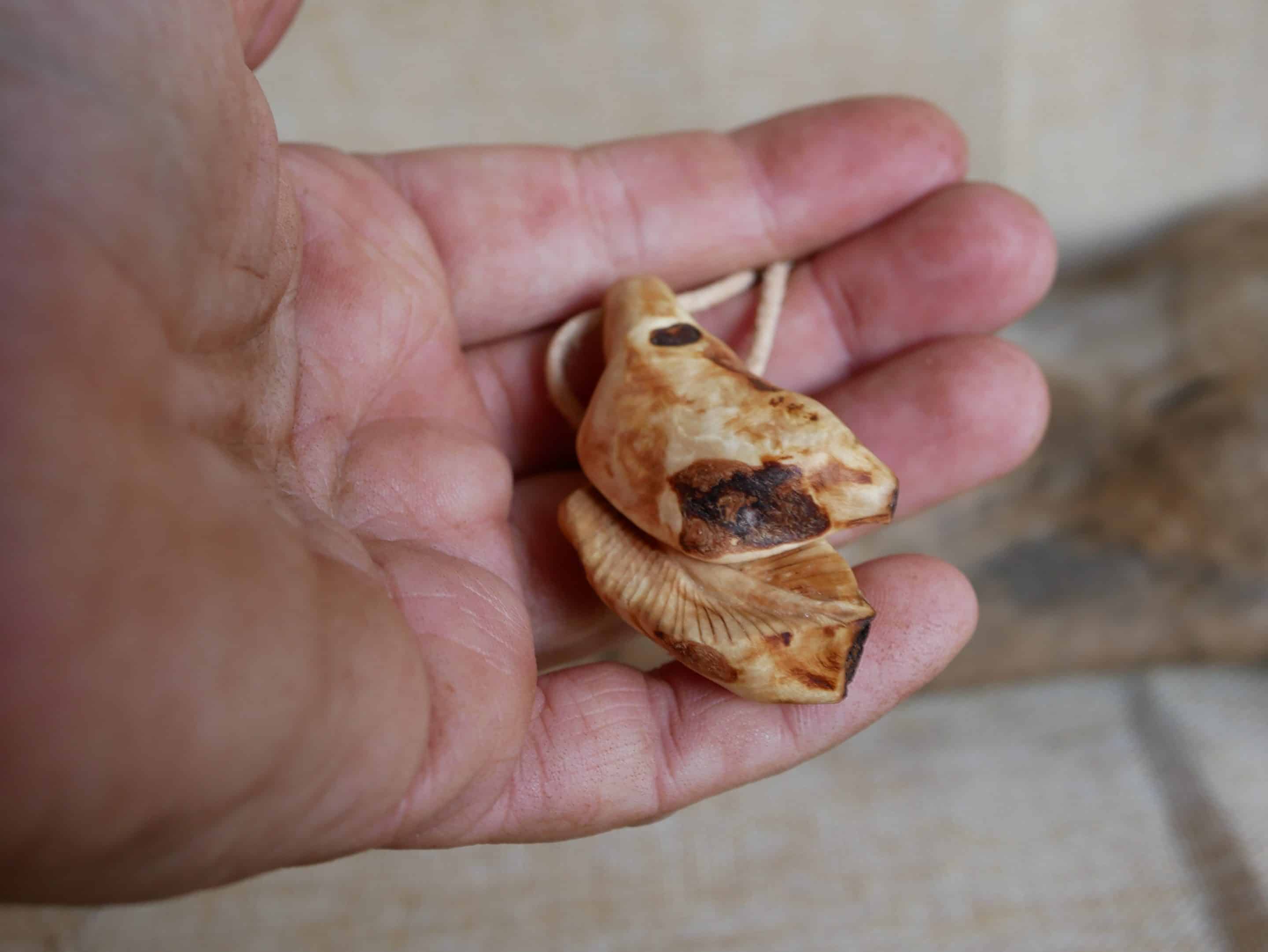 Federanhänger aus Baumperlen geschnitzt