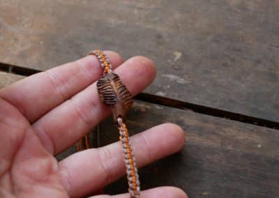 Makramee Armband mit einer Baumperle als Feder geschnitzt
