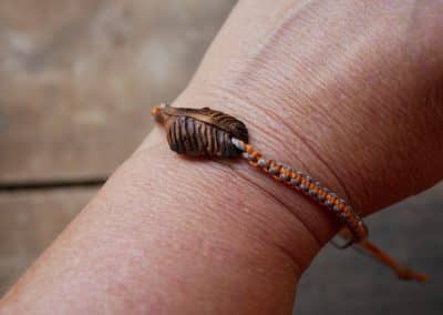 Makramee Armband mit einer Baumperle als Feder geschnitzt