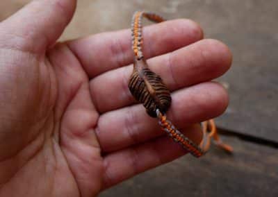 Makramee Armband mit einer Baumperle als Feder geschnitzt