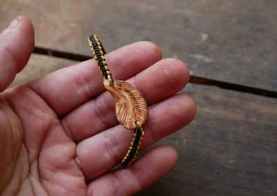 Makramee Armband mit einer Baumperle als Feder geschnitzt