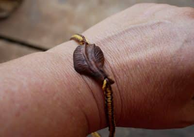 Makramee Armband mit einer Baumperle als Feder geschnitzt