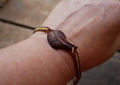 Makramee Armband mit einer Baumperle als Feder geschnitzt