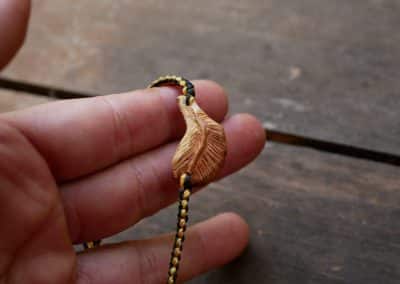 Makramee Armband mit einer Baumperle als Feder geschnitzt