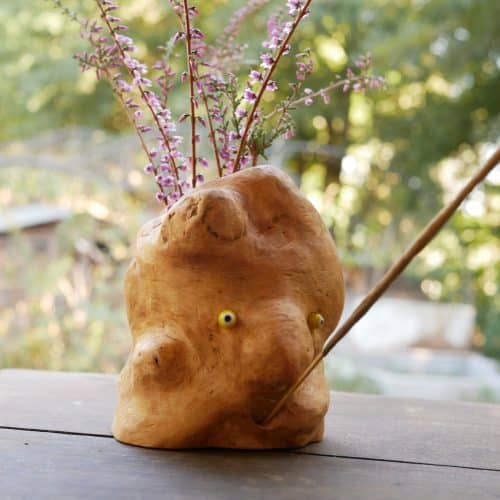 Vase aus Großer Baumperle für Trockenblumen und einem eingeeschnitzten Gesicht und die Möglichkeit ein Räucherstäbchen in den Mund zu stecken