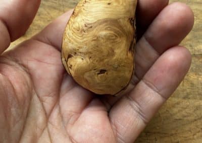 Buch aus Baumperle mit einer eingeschnitzten Feder