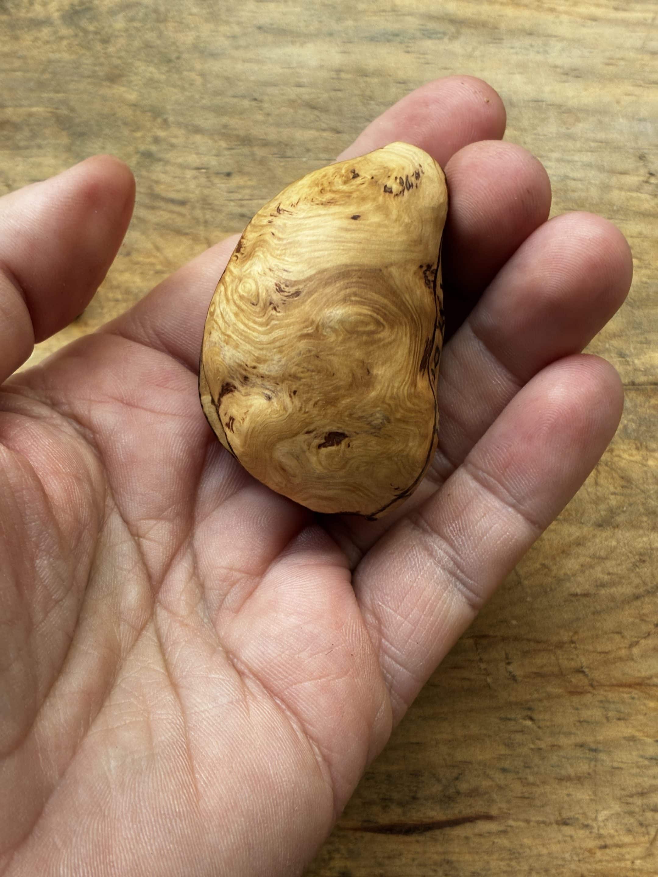 Buch aus Baumperle mit einer eingeschnitzten Feder