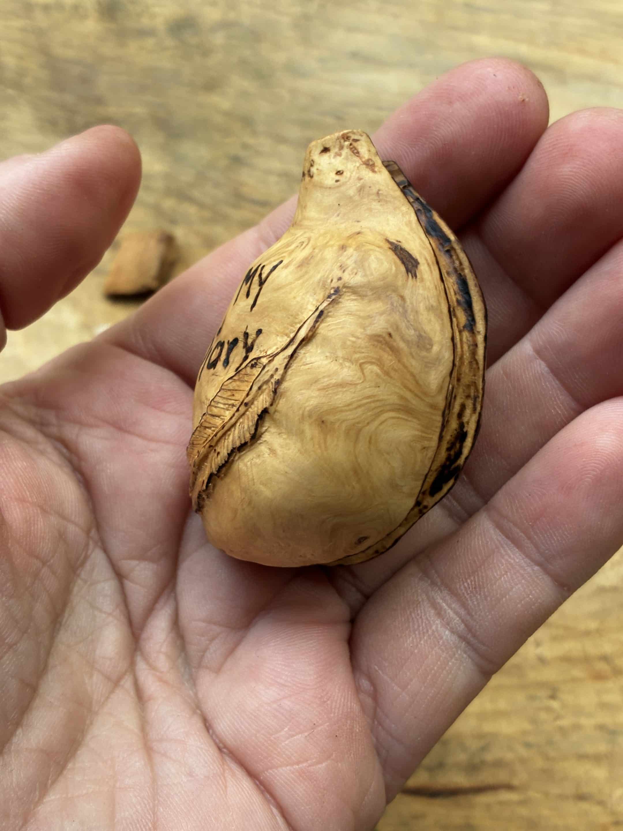 Buch aus Baumperle mit einer eingeschnitzten Feder