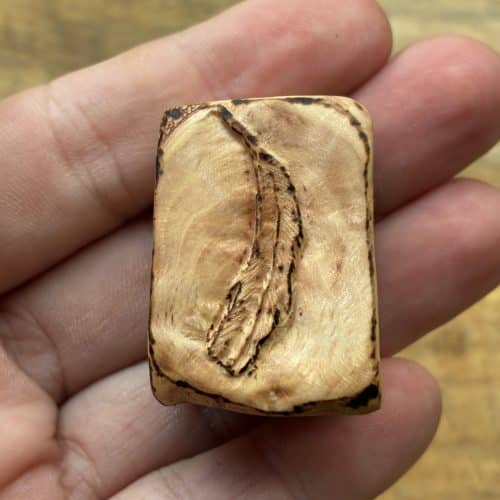 Buch aus Baumperle mit einer eingeschnitzten Feder