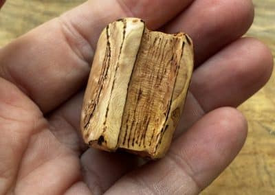 Buch aus Baumperle mit einer eingeschnitzten Feder