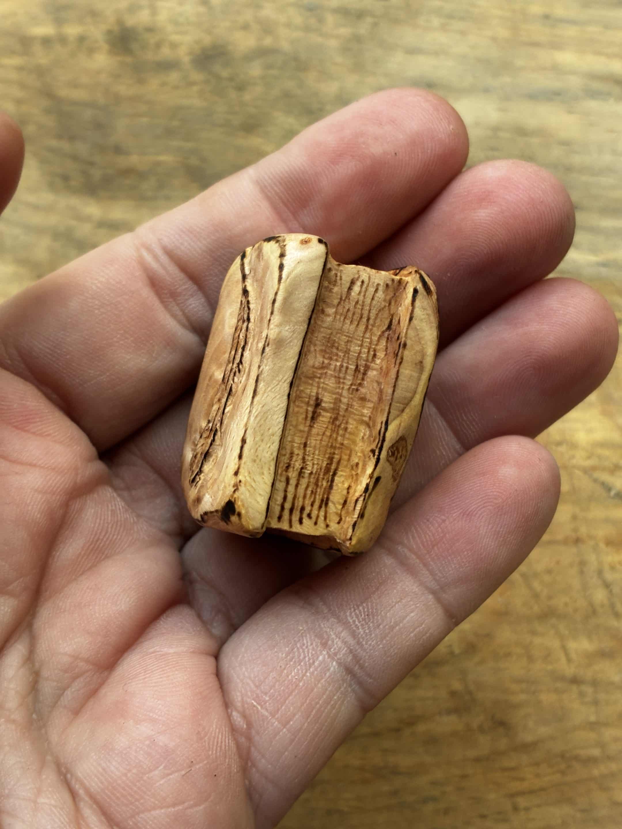 Buch aus Baumperle mit einer eingeschnitzten Feder