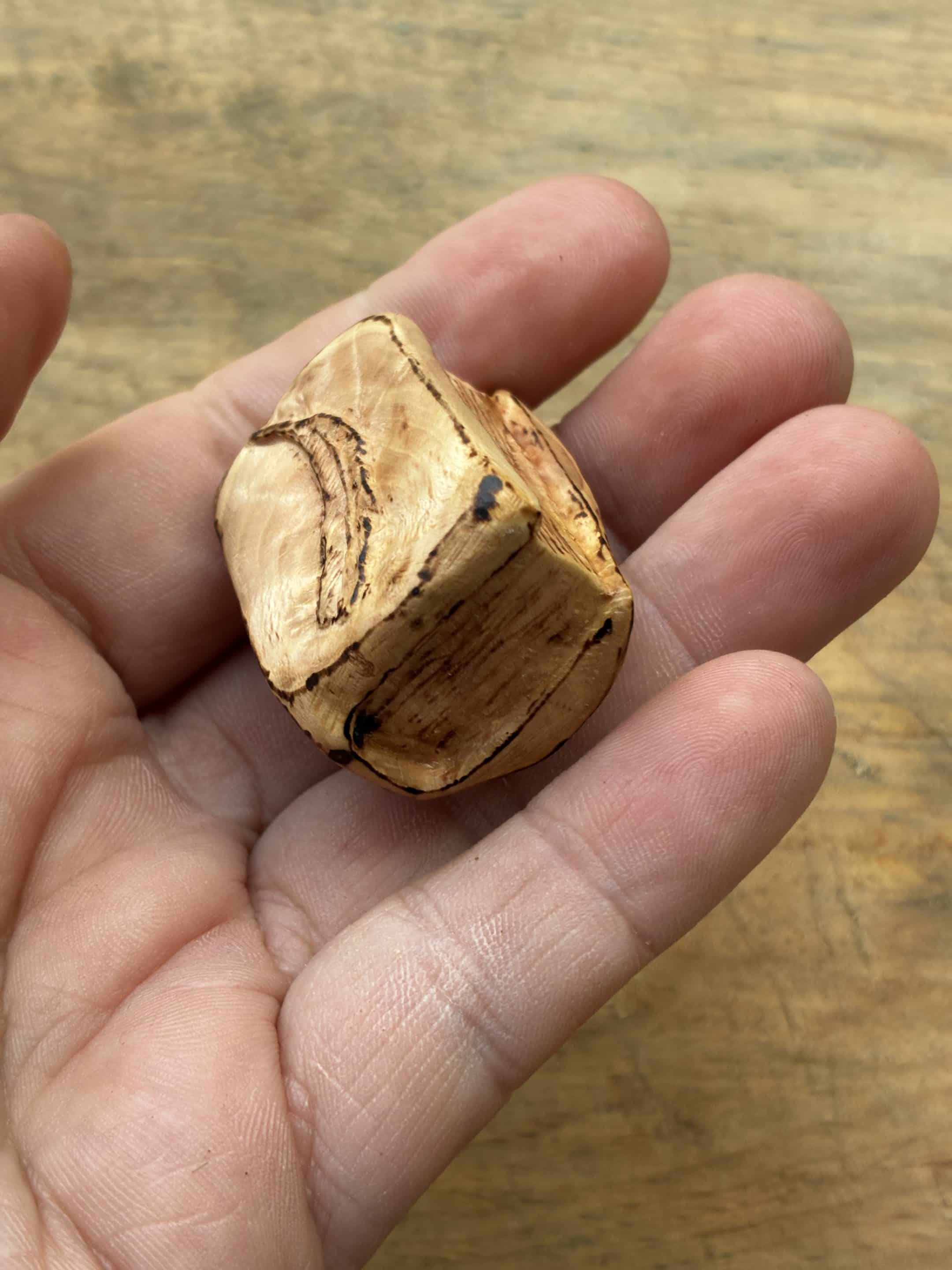 Buch aus Baumperle mit einer eingeschnitzten Feder