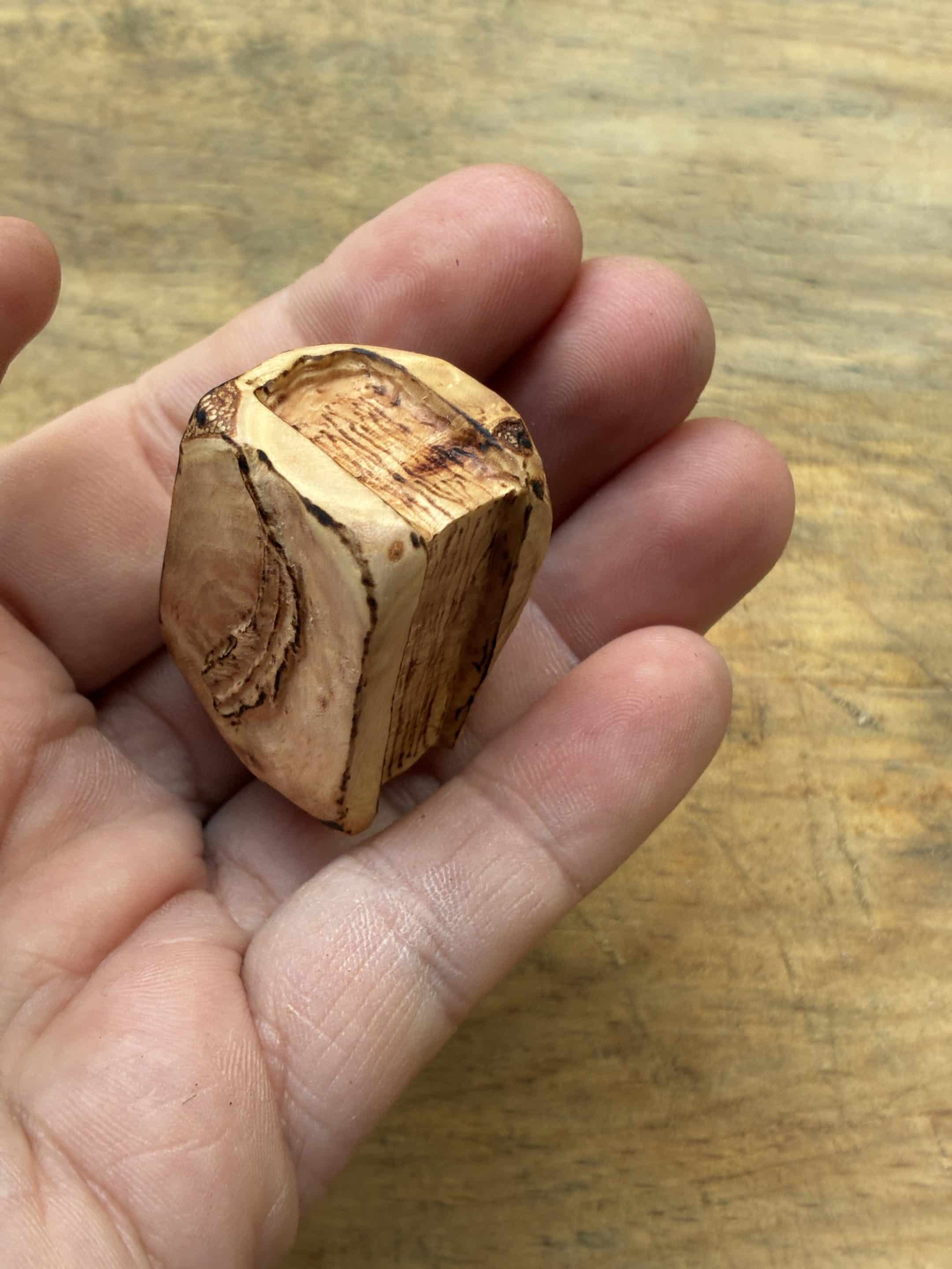 Buch aus Baumperle mit einer eingeschnitzten Feder