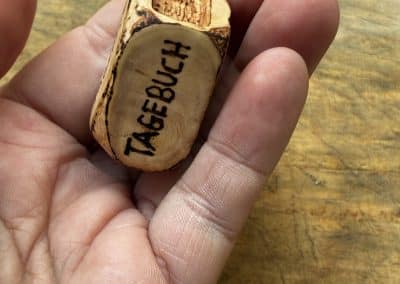 Buch aus Baumperle mit einer eingeschnitzten Feder