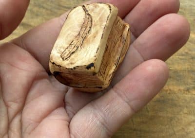 Buch aus Baumperle mit einer eingeschnitzten Feder