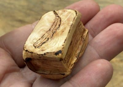 Buch aus Baumperle mit einer eingeschnitzten Feder