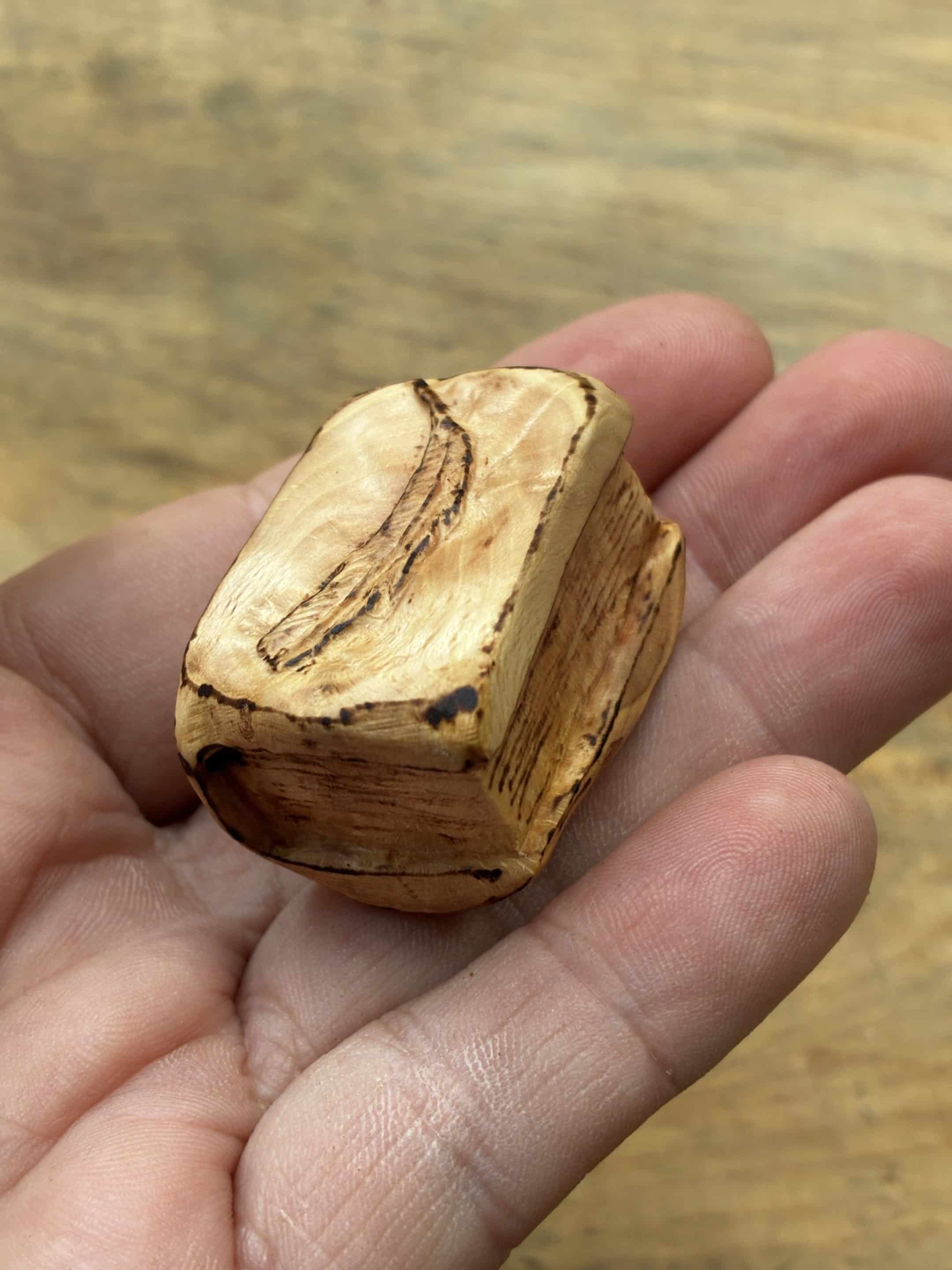 Buch aus Baumperle mit einer eingeschnitzten Feder